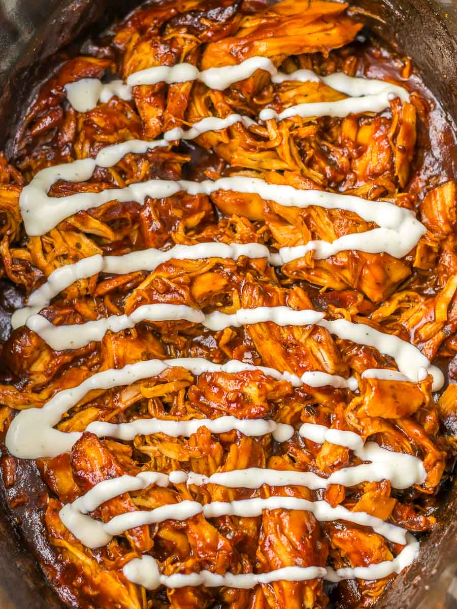 Shredded barbecue chicken topped with drizzles of white sauce.