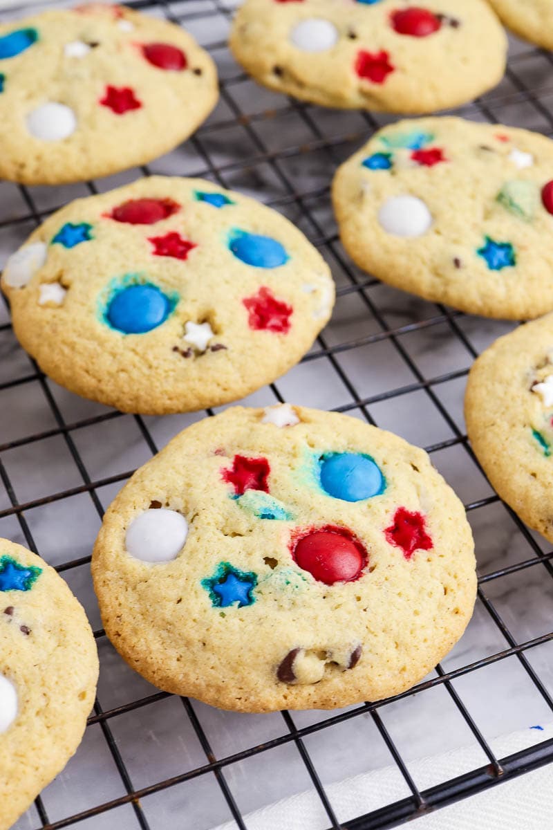Close-up of cookies on a cooling rack, featuring colorful red, white, and blue candy and star-shaped decorations.